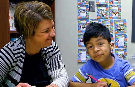 Teacher and student sitting next to each other.